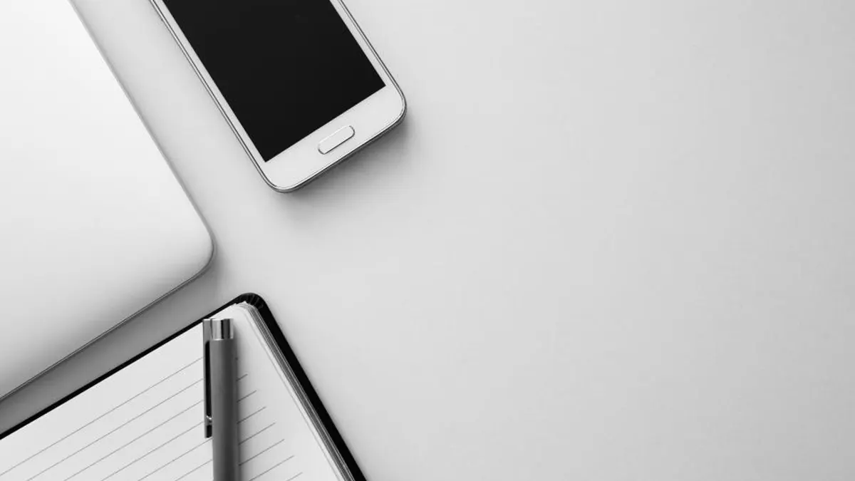 Смартфон, планшет и блокнот на столе